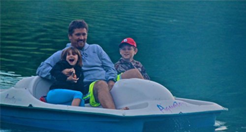 kids in a paddle boat on the lake